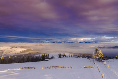 Scenic view of snow covered landscape against sky during sunset