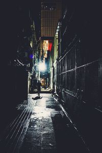 Illuminated street amidst buildings in city at night