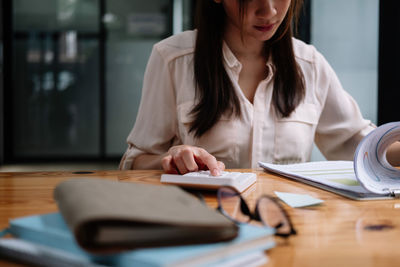 Midsection of businesswoman working at table