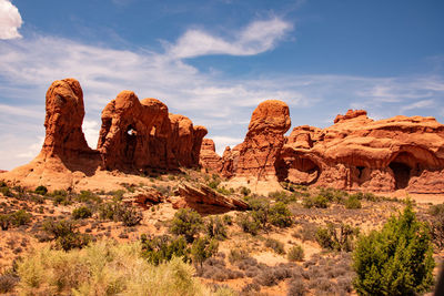 Rock formations on landscape against cloudy sky