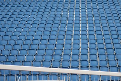 Low angle view of metal fence against blue sky