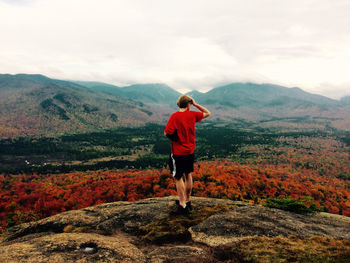 Yong man looks at spectacular view from the top of an adirondack mountain