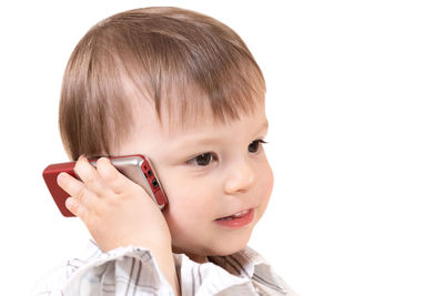 Close-up portrait of cute boy against white background