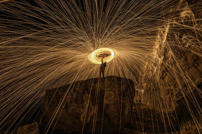 Person making wire wool on rock at night