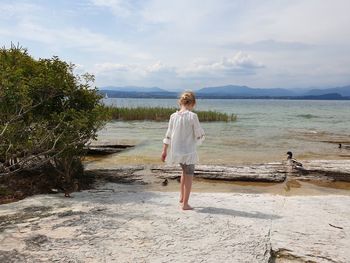 Rear view of woman looking at sea against sky