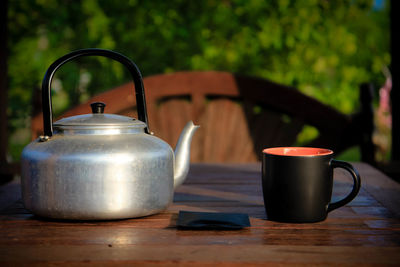 Close-up of tea cup with kettle on table