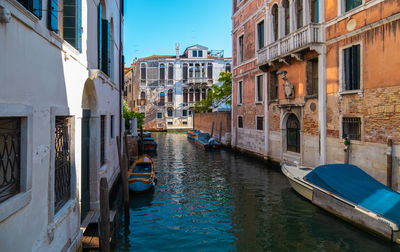 View of empty canals of venice with apartment buildings in the background.