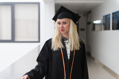 Young woman wearing graduation gown