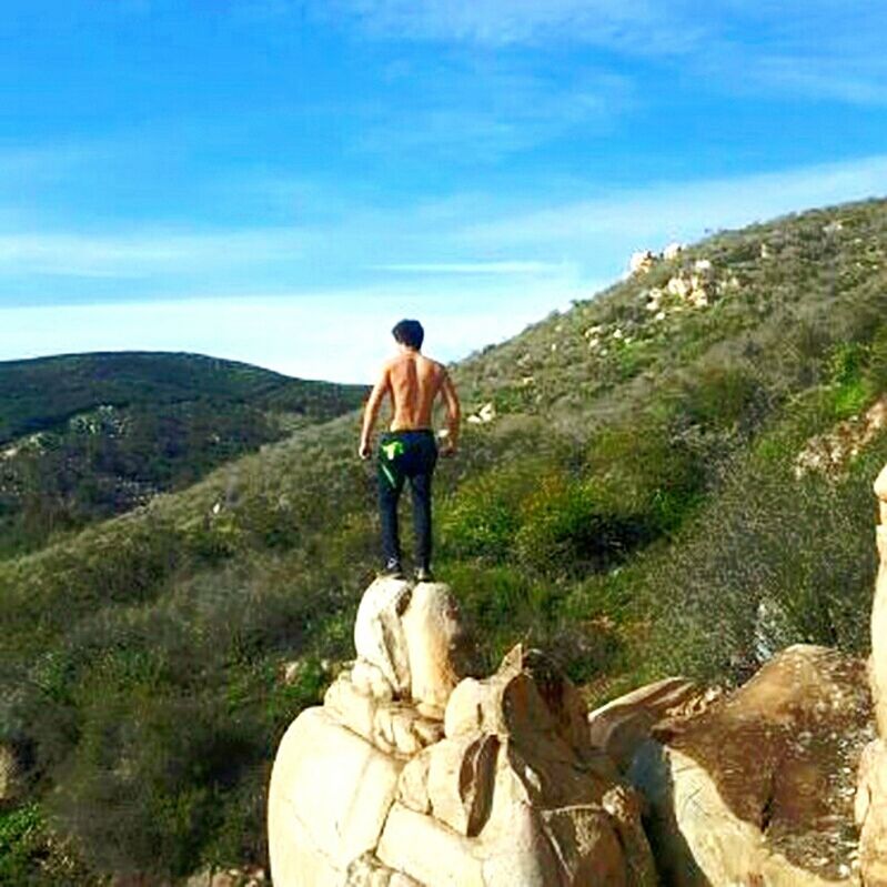 FULL LENGTH REAR VIEW OF A MAN WALKING ON LANDSCAPE