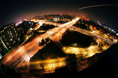 High angle view of light trails on highways in city at night