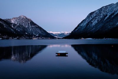 Scenic view of lake and mountains against clear sky
