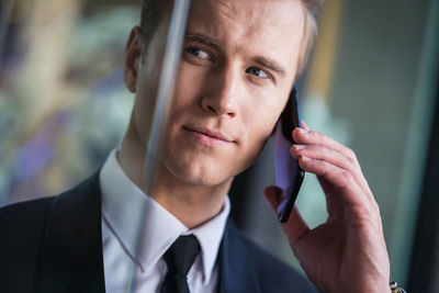 Close-up of handsome businessman listening over phone