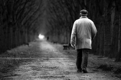 Rear view of woman walking on road