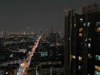 Illuminated cityscape against sky at night