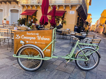 Bicycle on street against building in city