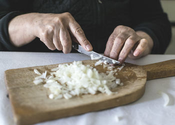 Cropped hand of person preparing food on cutting board