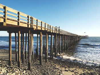 Pier leading towards sea against sky