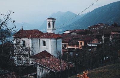 Houses in town against sky during winter