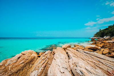 Scenic view of beach against blue sky