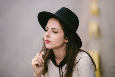 Portrait of young woman wearing black hat