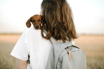 Woman holding dachshund puppy outdoor