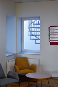 Empty chairs and table against wall at home