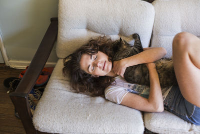 Portrait of a smiling young woman lying on sofa