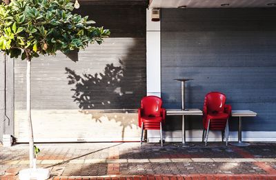 Red chairs on table against building