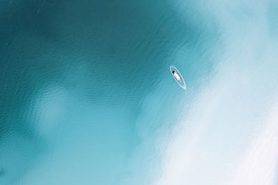 Kite flying over sea against blue sky