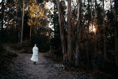 Rear view of woman walking in forest