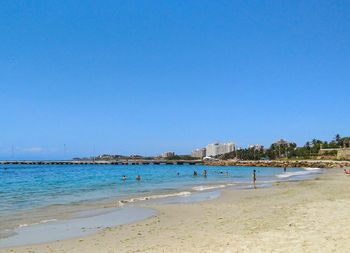 Scenic view of beach against clear blue sky