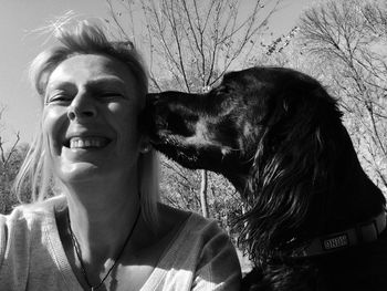 Gordon setter dog kissing cheerful woman