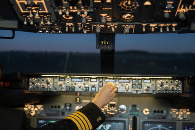 Cropped hand of pilot controlling knob