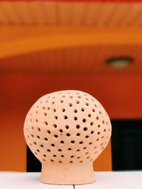 Close-up of orange table against wall