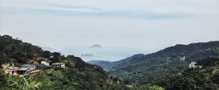 Houses on mountain against sky