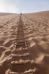 Scenic view of sand dune on beach against sky