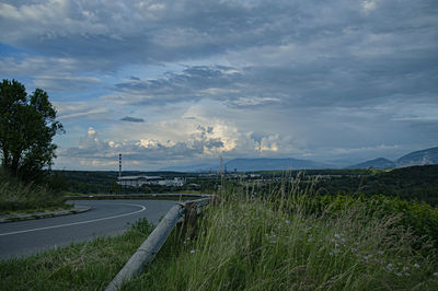 Road amidst field against sky