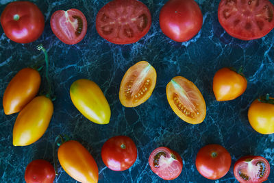 Autumn vegetables. colorful red, orange and yellow tomatoes on green marble background. 