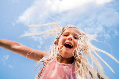 Blonde girl looking down with a blue sky background