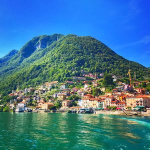 Town by sea against clear blue sky