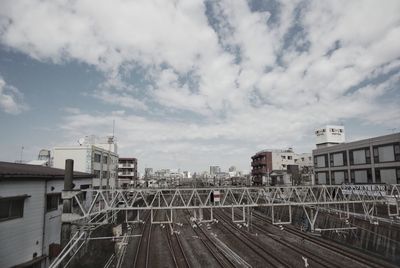 Railroad tracks against sky in city