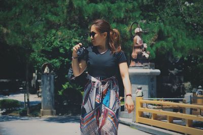Full length of woman standing against trees