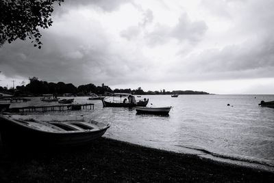 Boats moored on sea against sky