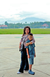 Full length portrait of happy mother and daughter against sky