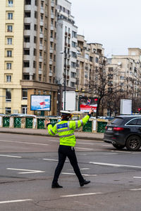 Full length rear view of man cycling on street