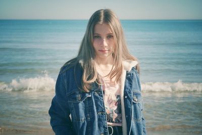 Portrait of girl standing on beach against sea