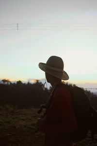 Side view of man standing against sky during sunset