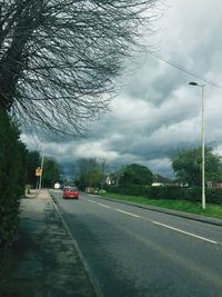 Country road against cloudy sky