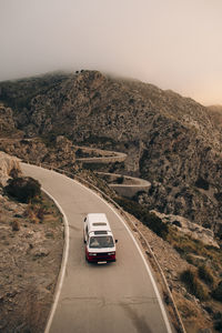 High angle of van moving on road amidst mountains