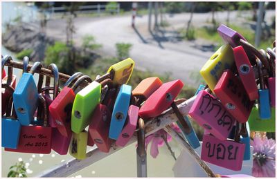 Close-up of colorful padlocks on railing